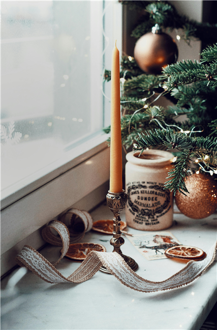 A candle and ornaments on a window sill by Valeriia Harbuz