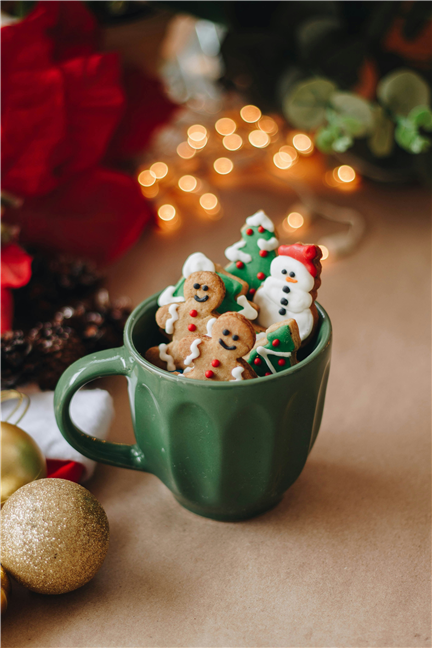 A cup filled with Christmas cookies on top of a table by Isabela Kronemberger